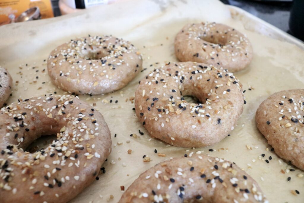 whole grain everything bagels on pan ready to be baked