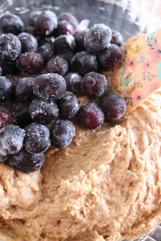 muffin batter with frozen blueberries on top