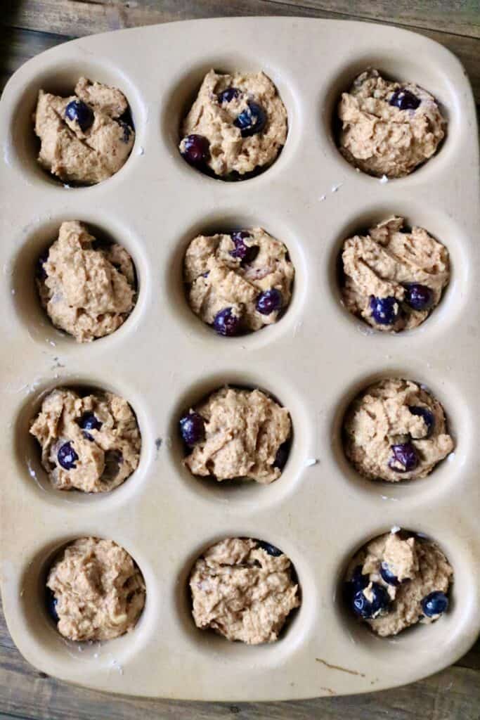 fresh milled blueberry banana muffin batter in a muffin pan