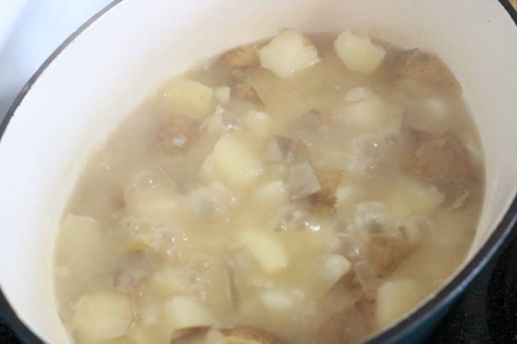 creamy potato vegetable soup potatoes in pot with boiling broth