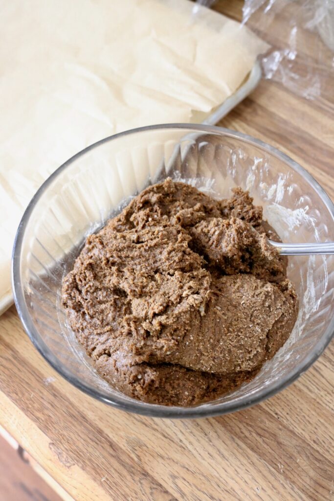 sourdough whole grain molasses cookie dough on counter top next to baking sheet
