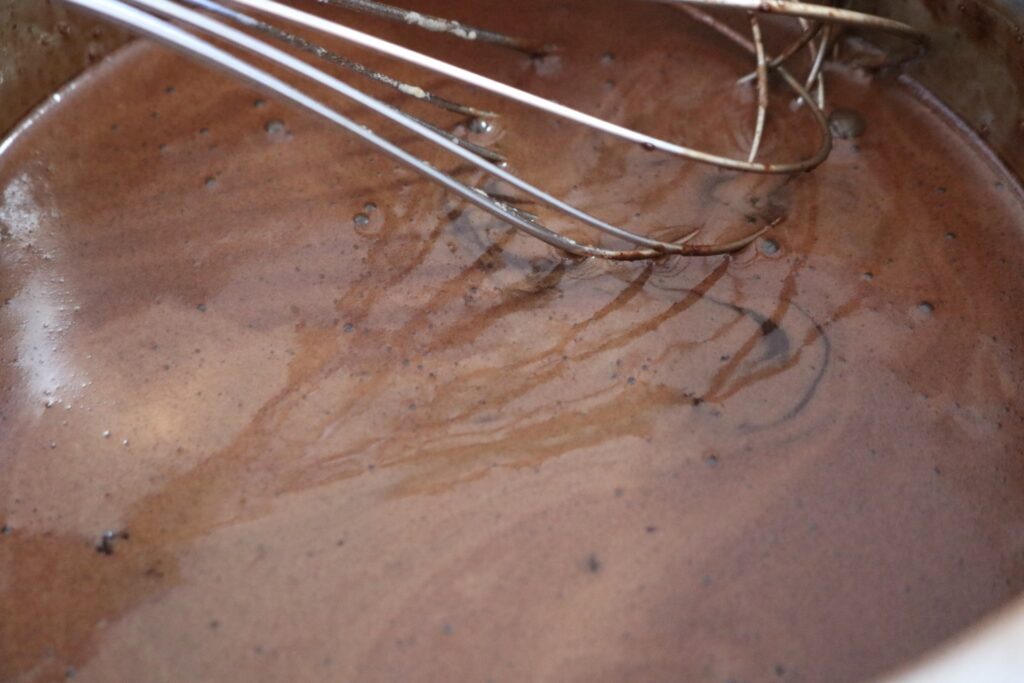 mocha sauce in a saucepan with a whisk in it