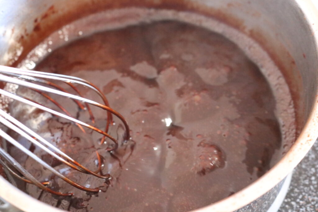 boiling chocolate mocha sauce in a pan with a whisk
