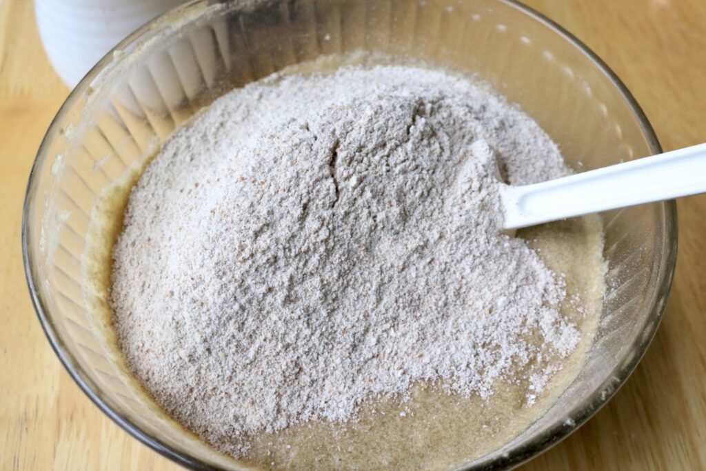 flour on top of wet ingredients in a bowl
